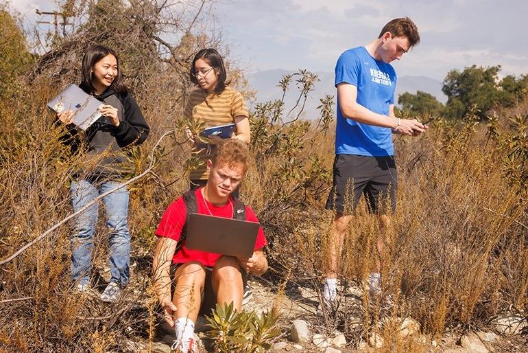 four students conduct research in the field at the robert Redford conservancy